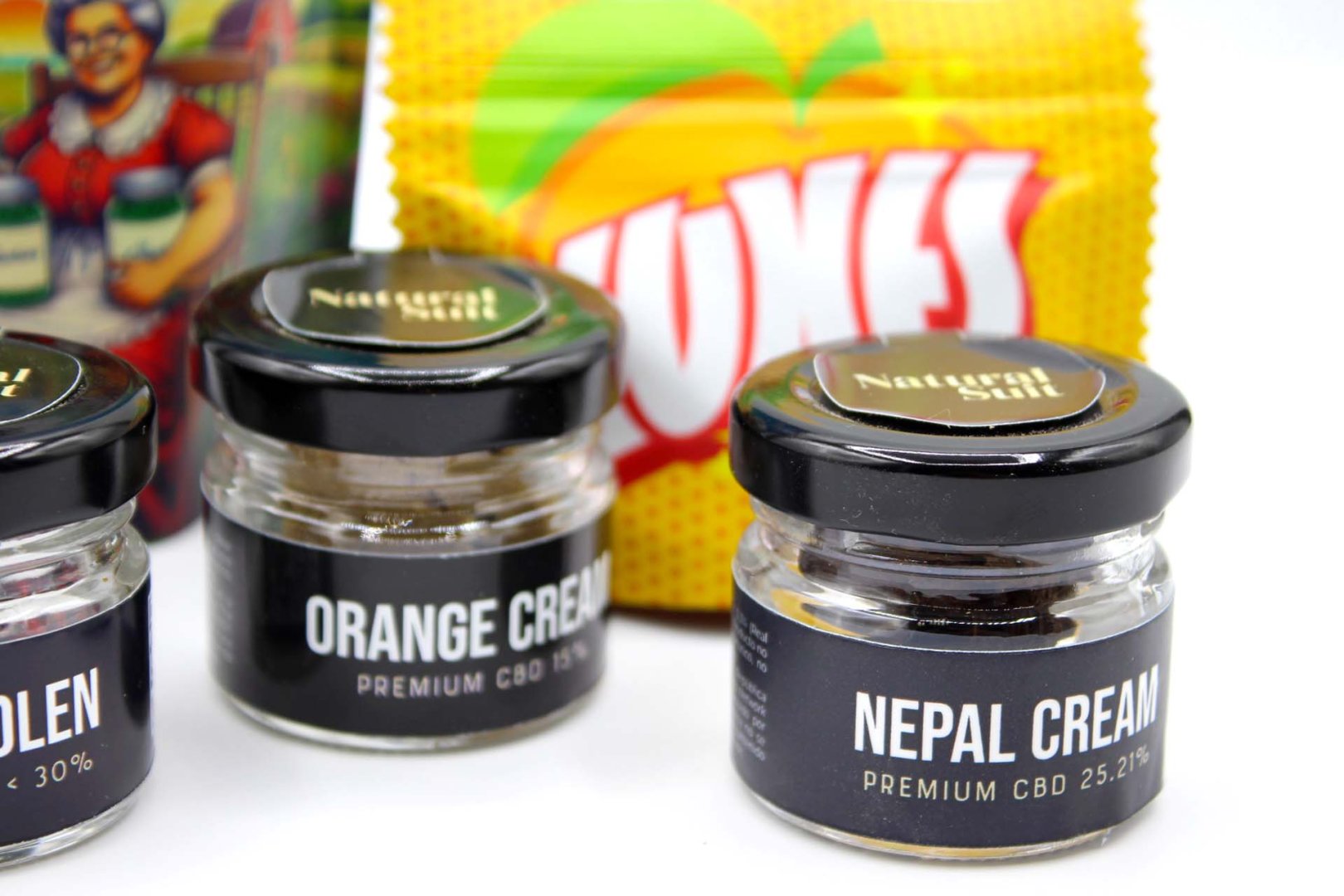 Frascos de resinas CBD Nepal Cream y Orange Cream con fondos coloridos