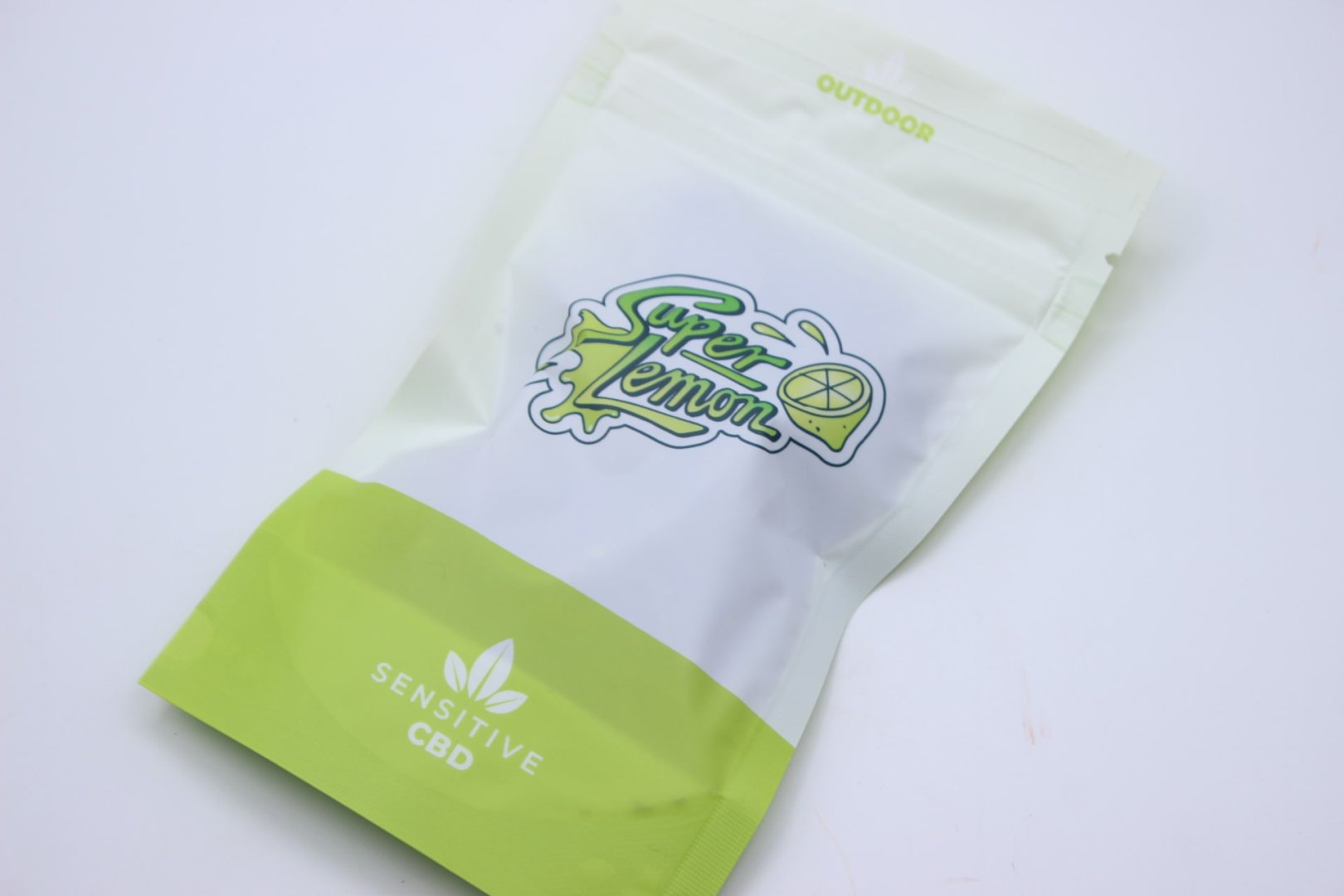 Envase de flor CBD Greenhouse con variedad Super Lemon destacada