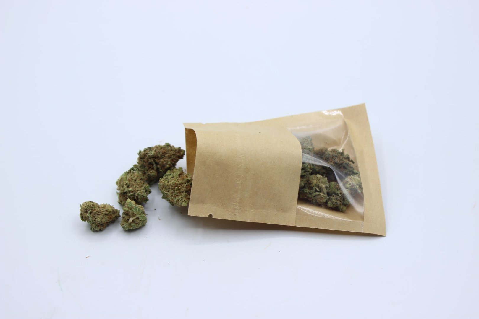 Bolsa kraft abierta con flores de CBD secas y apagadas